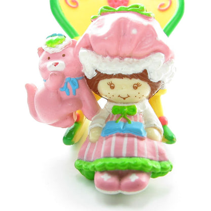 Strawberry Shortcake reading to Custard in a rocking chair miniature figurine
